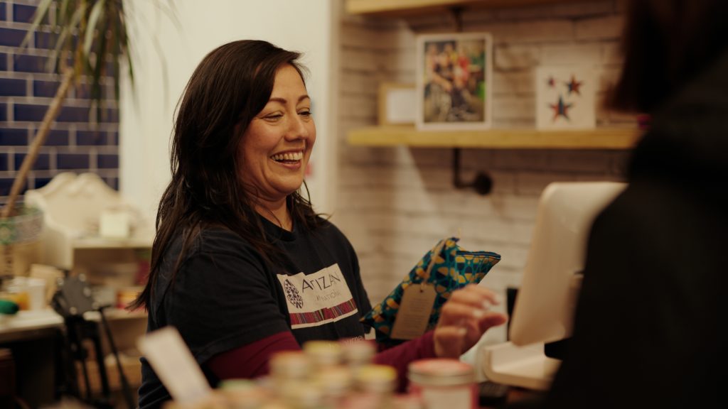 A smiling volunteer serving in our shop