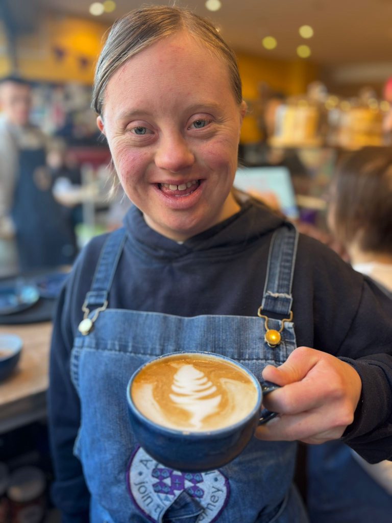 A waitress at our Harrogate cafe serving a coffee